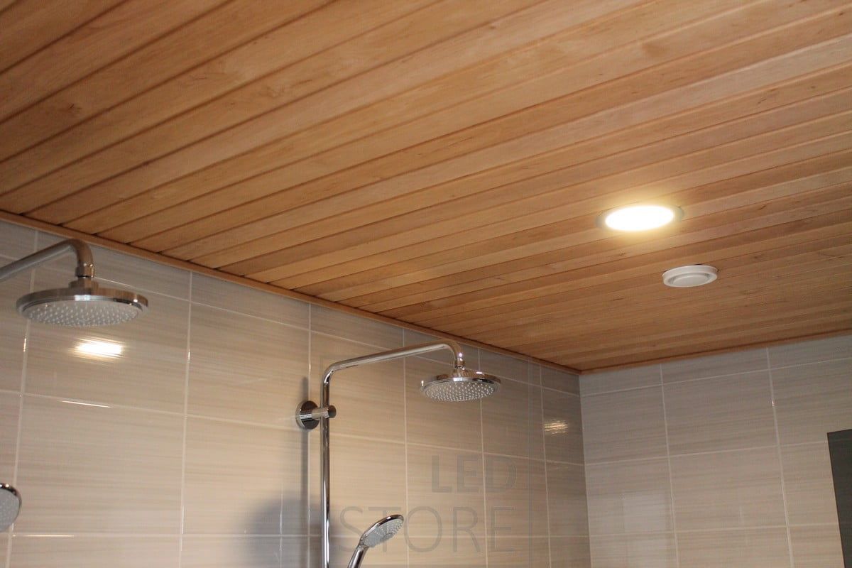 A circular LED ceiling light in the washroom, illuminating the ceiling with warm, even light. The luminaire is moisture-proof (IP54). Ledstore.fi